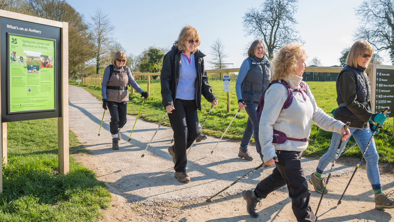 A group of women on a nordic walking trip on a footpath at Avebury.